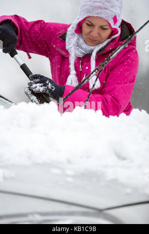 Femme enlever la neige de sa voiture, problème d'hiver Banque D'Images