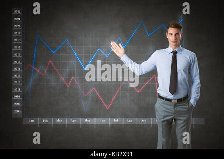 Businessman with virtual finances graphic en arrière-plan Banque D'Images