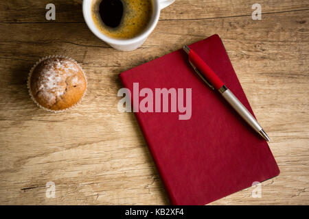 Bloc-notes avec stylo rouge sur la table en bois, vue du dessus Banque D'Images