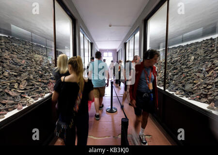 Les touristes à la recherche de tas de chaussures appartenant à des prisonniers à Auschwitz camp de concentration Nazi museum, Pologne Banque D'Images