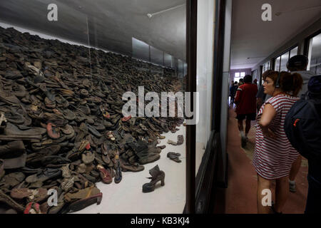 Les touristes à la recherche de tas de chaussures appartenant à des prisonniers à Auschwitz camp de concentration Nazi museum, Pologne Banque D'Images