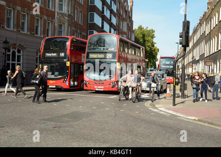 Les vélos Transport for London à un carrefour en plus de deux bus à impériale rouge avec un taxi de Londres en arrière-plan à Londres en Angleterre Banque D'Images