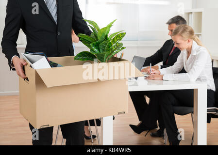 Close-up of businessman carrying effets personnels in office Banque D'Images