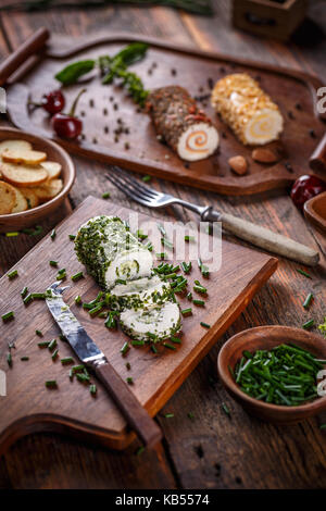 Délicieux fromage apéritif. à l'aide de fines herbes fromage servi sur une planche à découper Banque D'Images