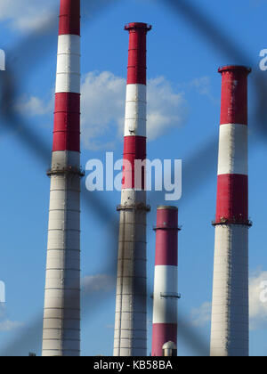 Les cheminées, photographié par chain barrière, peint en rouge et blanc pour avertir les aéronefs de passage Banque D'Images