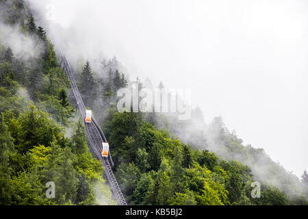 Deux wagons crossing sur un deux-rail funiculaire dans les montagnes de l'Hallstatt, Autriche, en un jour brumeux Banque D'Images