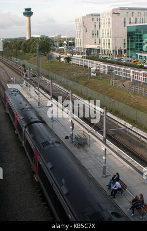 CrossCountry train sur la plate-forme, en face de la tour de contrôle, et d'autres bâtiments à l'aéroport de Stansted, Colchester, Essex, Angleterre Banque D'Images