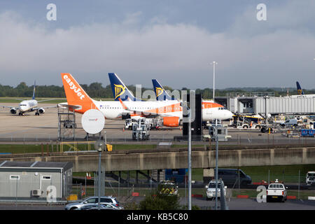 Deux avions de Ryanair et easyJet en attente d'un avion sur le tarmac à l'aéroport de Stansted, Colchester, Essex, Angleterre, avec un autre plan de circulation au sol Banque D'Images