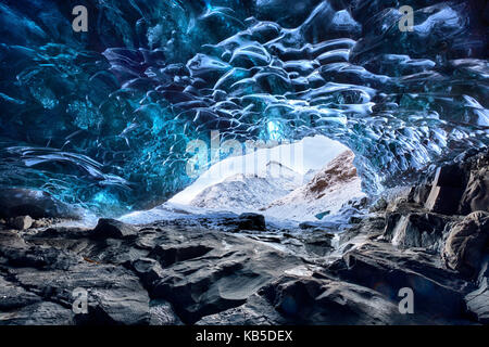 Vue depuis l'intérieur de la caverne de glace sous le glacier de Vatnajokull vers les montagnes couvertes de neige, près de lagon Jökulsárlón, le sud de l'Islande Banque D'Images