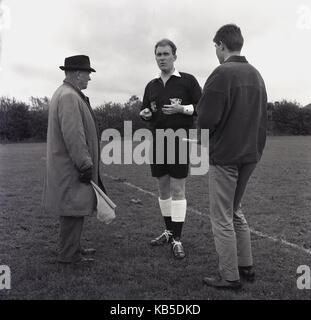 Années 1960, historiques, arbitre de football amateur parle à ses deux juges sur le terrain avant le match, Angleterre, Royaume-Uni. Banque D'Images