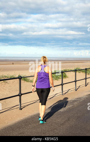 Femme qui court sur la promenade du front de mer à Crosby, Sefton, Merseyside. 28th septembre 2017. Météo Royaume-Uni. Journée ensoleillée sur l'estuaire de Mersey pendant qu'un jogger fait de l'exercice sur la vaste promenade de Mariners Way. Crédit; crédit: MediaWorldImages/Alamy Live News Banque D'Images