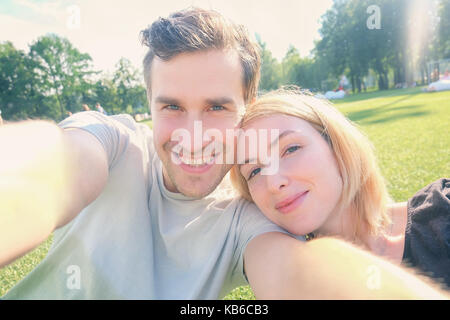 Young couple smiling selfies tout en tenant Banque D'Images