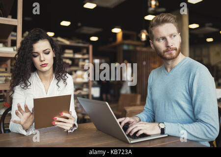Couple heureux de passer du temps au café working on laptop Banque D'Images