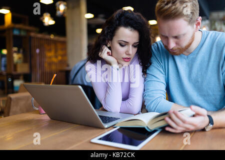 De jeunes étudiants de passer du temps dans la lecture de livres café Banque D'Images