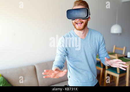 Homme portant un casque de réalité virtuelle à la maison Banque D'Images