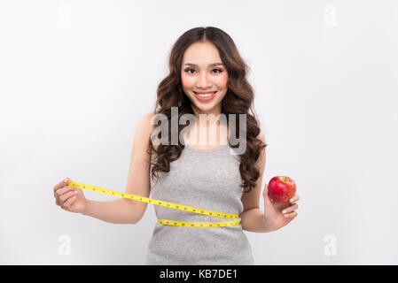 La mesure de sa taille et femme holding apple. perdre poids concept. Banque D'Images