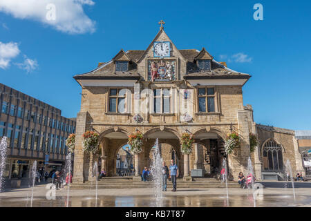 Les gens autour de l'historique du 17ème siècle, baignée de Guildhall (également connu sous le nom de Croix de beurre), dans le centre-ville de Peterborough, Cambridgeshire, Angleterre, Royaume-Uni. Banque D'Images