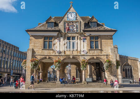 Les gens autour de l'historique du 17ème siècle, baignée de Guildhall (également connu sous le nom de Croix de beurre), dans le centre-ville de Peterborough, Cambridgeshire, Angleterre, Royaume-Uni. Banque D'Images