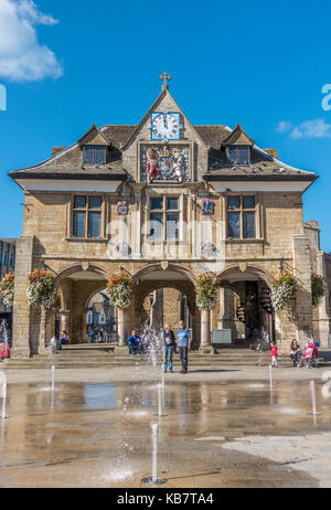 Les gens autour de l'historique du 17ème siècle, baignée de Guildhall (également connu sous le nom de Croix de beurre), dans le centre-ville de Peterborough, Cambridgeshire, Angleterre, Royaume-Uni. Banque D'Images