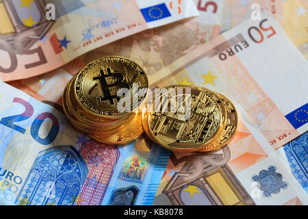 Les bitcoins or empilées sur les billets en euros contexte Banque D'Images