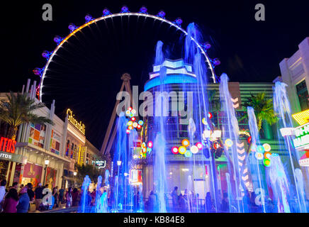 Les touristes et les visiteurs profitent de la marche de nuit autour du centre commercial Shoppes et magasins à côté du High Roller à Las Vegas, Nevada. Banque D'Images