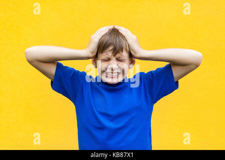 Émotions et sentiments mauvais concept. maux. Jeune garçon toucher la tête et ont une migraine. Piscine shot Banque D'Images