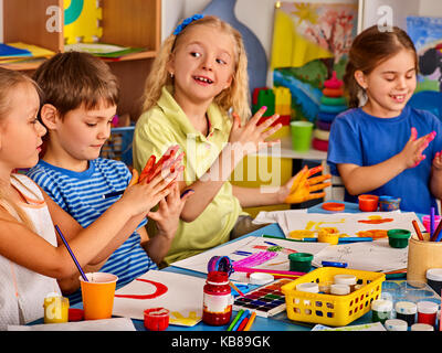 Petite fille aux étudiants la peinture au doigt en art school class. Banque D'Images