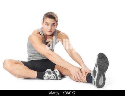 Portrait de jeune homme sportif faisant des exercices étend isolé sur fond blanc Banque D'Images