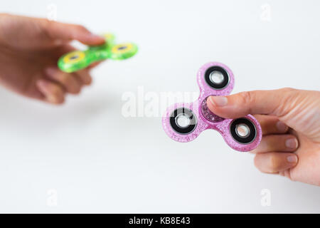 Close up de deux mains jouant avec fidget spinners Banque D'Images