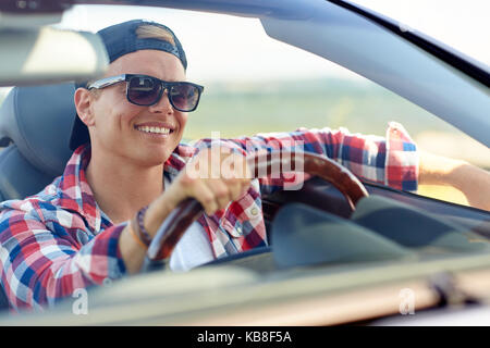 Heureux jeune homme dans des tons driving convertible car Banque D'Images