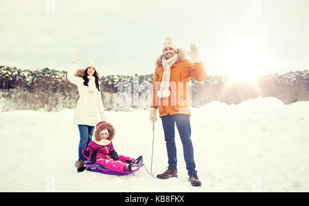 Famille heureuse avec balades en traîneau en hiver en plein air Banque D'Images