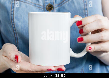 Fille est holding white cup, tasse en mains. immersive pour les produits exposés. Banque D'Images