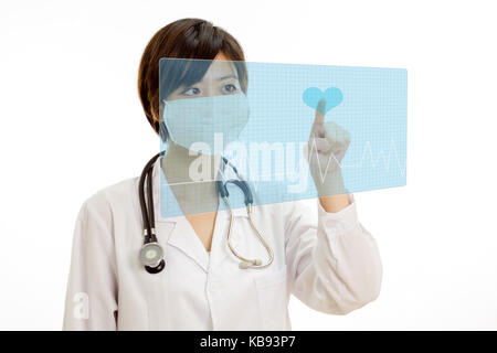 Chinese female doctor with stethoscope en appuyant sur bouton coeur virtuel sur l'écran d'impulsions Banque D'Images