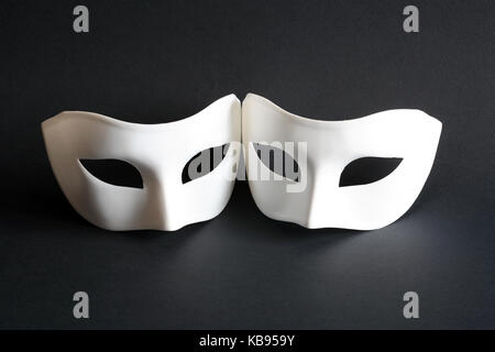 Deux masques vénitiens blancs sur fond sombre Banque D'Images