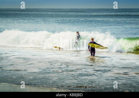 Longboard surf dans l'océan Pacifique au large de Cape Kiwanda, Pacific City, Oregon, United States. Banque D'Images