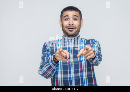 J'en ai besoin ! Le bonheur homme pointant du doigt en caméra et ont une apparence joyeuse. studio shot Banque D'Images