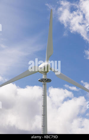 Wind turbine sur un ciel bleu et nuages blancs moelleux idéal pour les concepts d'énergie renouvelable Banque D'Images