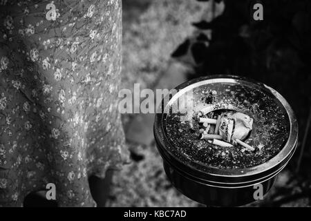 Le noir et blanc close-up de vieux cendrier vintage meuble rempli de cigarettes Banque D'Images