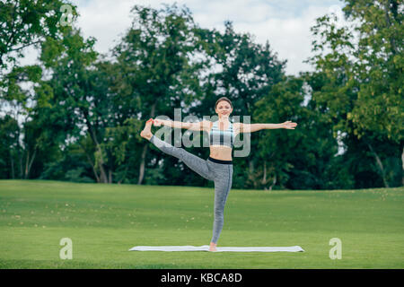 Woman practicing yoga in park Banque D'Images