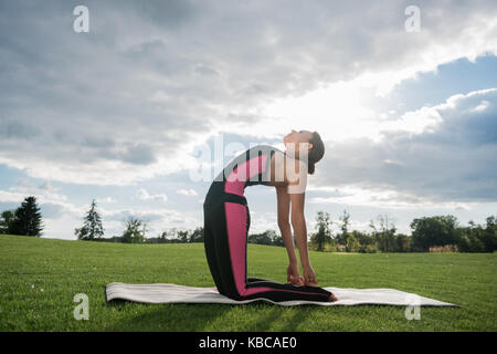 Woman standing in camel yoga pose Banque D'Images