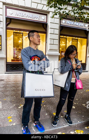 Parizska Street, Prague shopping, République tchèque touristes asiatiques en face de la boutique de luxe Patek Philippe avec des sacs à provisions en papier Gucci Banque D'Images