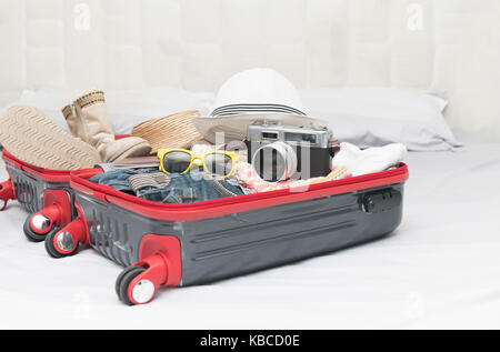 Voyage Accessoires de costumes. Passeport, assurance, appareil photo, lunettes, vêtements, démarrage en valise, préparé pour le voyage et travel concept Banque D'Images