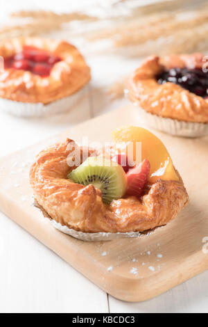 Pain danois avec orange kiwi et fraises sur fond de bois blanc, de l'alimentation boulangerie Banque D'Images