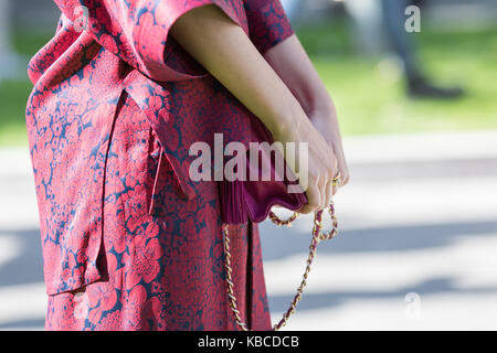 Milan, Italie - 22 septembre 2017 : modèle portant une robe violette et un sac à main violet pendant le défilé armani, photographié dans la rue Banque D'Images