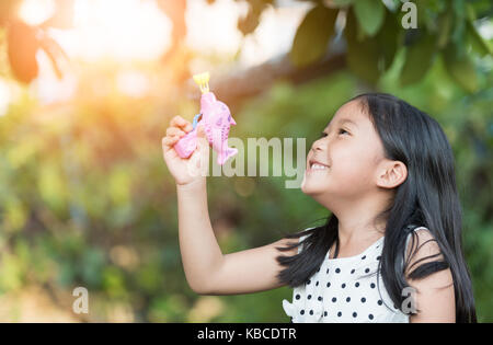 Happy asian girl playing gun savon bulle à la maison, concept sain Banque D'Images