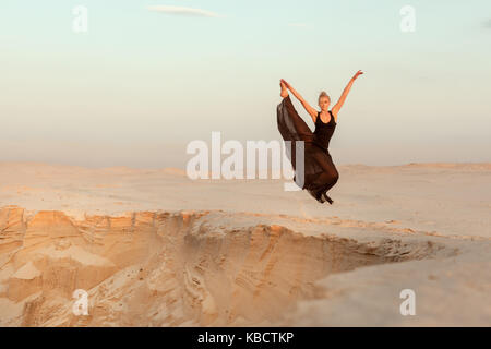 Woman in dance vole au-dessus de l'abîme dans le désert. Banque D'Images