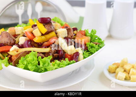 Salade de foie de poulet, haricots, tomates, paprika doux, croûtons et vinaigrette balsamique. Banque D'Images