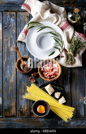 Ingrédients pour la cuisine italienne traditionnelle Pasta alla carbonara spaghettis non cuits., la pancetta bacon, fromage parmesan, d'oeuf, sel, poivre, plaque, à vide Banque D'Images