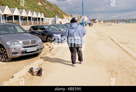 Septembre 2017 bournemouth - surpoids femme exerçant son chien sur la plage Banque D'Images
