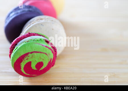 Macarons colorés et doux des cookies sur fond de bois avec des espaces blancs,selective focus, dessert. Banque D'Images